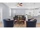 A comfortable living room with hardwood floors, ceiling fan, stylish furniture, and an adjacent modern kitchen at 129 Marblehead Dr., Little River, SC 29566