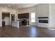 Open concept view showcasing kitchen island, stainless appliances, modern fireplace, and wood flooring at 148 Joyce Dr, Longs, SC 29568