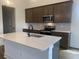 Close up of the kitchen island, sink, stainless steel appliances, and wooden cabinets at 148 Joyce Dr, Longs, SC 29568