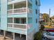 Capture of balconies and condos showcasing ample parking spaces, and three-story building at 1510 S Ocean Blvd. # 101, Surfside Beach, SC 29575