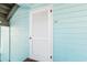 Close-up of an exterior door with white louvers on a light blue building with a door mat at 1510 S Ocean Blvd. # 101, Surfside Beach, SC 29575