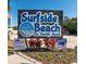 Surfside Beach sign proclaims, 'The Gathering Beach,' with colorful flowers in the landscape at 1510 S Ocean Blvd. # 101, Surfside Beach, SC 29575