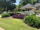 A front yard with a flowerbed, green lawn, and a view of the home's brick facade at 165 Greenbriar Ave., Pawleys Island, SC 29585