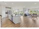 Bright open-concept living area with spacious kitchen, wood floors, and serene lake views at 2027 Copper Creek Loop, Longs, SC 29568