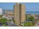 An impressive exterior of a high-rise condo featuring private balconies, lush landscaping, and a pool at 210 75Th Ave N # 4033, Myrtle Beach, SC 29572