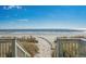 Picturesque beach access path with wooden stairs leading to a sunny beach and the ocean at 2301 S Ocean Blvd. # 825, Myrtle Beach, SC 29577