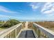 Convenient beach access point with a ramp and stairs, nestled between lush greenery, leading to the sandy beach at 2301 S Ocean Blvd. # 825, Myrtle Beach, SC 29577