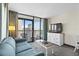 Living room features a blue sofa, coffee table, TV and balcony access with outdoor chairs at 2301 S Ocean Blvd. # 825, Myrtle Beach, SC 29577