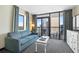 Comfortable living room with a blue sofa, table and access to a balcony with seating at 2301 S Ocean Blvd. # 825, Myrtle Beach, SC 29577