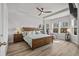 Bright main bedroom with a wooden ceiling fan, tray ceiling, and plenty of natural light from several windows at 2449 Campton Loop, Conway, SC 29527