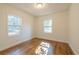 A cozy bedroom with hardwood floors and natural light streaming through two windows at 2505 Redwood St., Georgetown, SC 29440