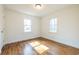 Bright bedroom showcasing hardwood floors, neutral walls, and natural light from two windows at 2505 Redwood St., Georgetown, SC 29440