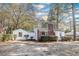 Charming home featuring white siding, brick chimney, green metal roof, and mature landscaping at 2505 Redwood St., Georgetown, SC 29440