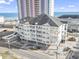 Exterior of the condo building showing its coastal location near a sandy beach and a pier at 3401 N Ocean Blvd. # 109, North Myrtle Beach, SC 29582