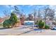 Inviting curb appeal with a charming cottage featuring a white picket fence, blue door and shutters, and mature trees at 3407 Poinsett St., North Myrtle Beach, SC 29582