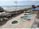 Inviting resort pool area with splash umbrella and jacuzzi overlooking the beach at 3601 N Ocean Blvd. # 1140, North Myrtle Beach, SC 29582