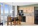 Modern kitchen with stainless steel appliances, wooden cabinets, and adjacent dining area with ocean views at 3601 N Ocean Blvd. # 1840, North Myrtle Beach, SC 29582
