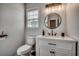 Modern bathroom featuring a white vanity, round mirror, contemporary lighting, and a toilet at 4225 Rivergate Ln., Little River, SC 29566