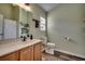 Functional bathroom with a wooden vanity, large mirror, and a toilet with shelving for storage at 4225 Rivergate Ln., Little River, SC 29566