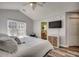 Spacious bedroom with a large window, comfortable bed, wood floors, and a view to the ensuite bathroom at 4225 Rivergate Ln., Little River, SC 29566