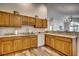 Well-lit kitchen with wooden cabinets, white subway tile backsplash, and a view into the living area at 4225 Rivergate Ln., Little River, SC 29566
