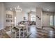 Bright open-concept living and dining area with hardwood floors, modern lighting, and a view to the front entrance at 4225 Rivergate Ln., Little River, SC 29566