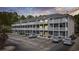 A condo building featuring large balconies and a spacious parking lot surrounded by trees in the background at 4506 W Harbour Ct. # U2, Little River, SC 29566