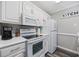 The kitchen features white appliances, white cabinets, and neutral wall paint with black trim at 4506 W Harbour Ct. # U2, Little River, SC 29566