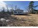 Exterior of a single-story home with gray siding with visible tire tracks on the muddy lot at 491 N Green Sea Rd., Loris, SC 29569