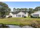 Well-maintained backyard with lush lawn and tranquil pond views at 5215 Southern Trail, Myrtle Beach, SC 29579