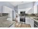 Modern kitchen featuring stainless steel appliances, granite countertops, and white cabinetry, offering a clean and functional design at 5215 Southern Trail, Myrtle Beach, SC 29579