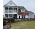 Charming two-story home with a double porch, manicured landscaping, and a bright red awning at 52505 Brescia St., Myrtle Beach, SC 29579