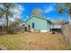 Quaint backyard featuring a picket fence, a small deck, a lawn with scattered leaves, and a charming green-painted home at 5520 N Kings Hwy., Myrtle Beach, SC 29577