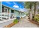 Home exterior with a side view of a wide driveway, green paint, wooden railings and a lush yard at 5520 N Kings Hwy., Myrtle Beach, SC 29577