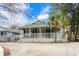 Charming coastal home featuring a spacious front porch, green exterior paint, and well-manicured landscaping at 5520 N Kings Hwy., Myrtle Beach, SC 29577