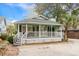 Charming coastal home featuring a spacious front porch, green exterior paint, and well-manicured landscaping at 5520 N Kings Hwy., Myrtle Beach, SC 29577
