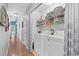 Bright laundry room featuring washer, dryer, and shelving along a hallway with hardwood floors at 5520 N Kings Hwy., Myrtle Beach, SC 29577