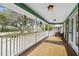 Covered porch with wood floors, white railing, ceiling fans and outdoor furniture at 5520 N Kings Hwy., Myrtle Beach, SC 29577