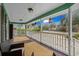 Wide porch with wooden flooring, white railings, outdoor lanterns, and seating area at 5520 N Kings Hwy., Myrtle Beach, SC 29577