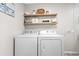 Functional laundry room with a new white washer and dryer set and wood shelving at 6001 - N75 S Kings Hwy., Myrtle Beach, SC 29575