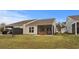 Spacious backyard featuring a screened porch, patio furniture, and lush green grass at 6614 Torino Lane, Myrtle Beach, SC 29572