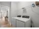 Well-lit laundry room with washer and dryer, convenient shelving, and neutral walls at 6614 Torino Lane, Myrtle Beach, SC 29572