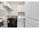 Efficient laundry room with modern black washing machine, white dryer, storage shelves, and white cabinets at 801 San Marco Ct. # C, Myrtle Beach, SC 29579