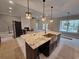 Kitchen island featuring granite countertop, stainless steel sink, and dark wood cabinets with a fireplace in the background at 8012 Old Reaves Ferry Rd., Conway, SC 29526