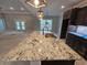 A spacious kitchen island features a granite countertop, a sink, and dark wood cabinets at 8012 Old Reaves Ferry Rd., Conway, SC 29526