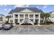 Inviting condo exterior showcasing large columns and a double staircase entry with ample parking spaces at 805 Sunswept Ct. # 102, Murrells Inlet, SC 29576
