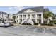 Inviting condo exterior showcasing large columns and a double staircase entry with ample parking spaces at 805 Sunswept Ct. # 102, Murrells Inlet, SC 29576