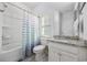 Bathroom with granite countertop vanity, shower/tub, and a light and blue striped shower curtain at 834 Summer Starling Pl., Myrtle Beach, SC 29577