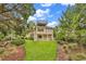 Beautiful backyard with mature trees and lush lawn, leading up to a charming two-story home at 994 Debordieu Blvd., Georgetown, SC 29440