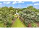Manicured backyard with a lush lawn, mature trees, and a pathway leading to a private dock at 994 Debordieu Blvd., Georgetown, SC 29440